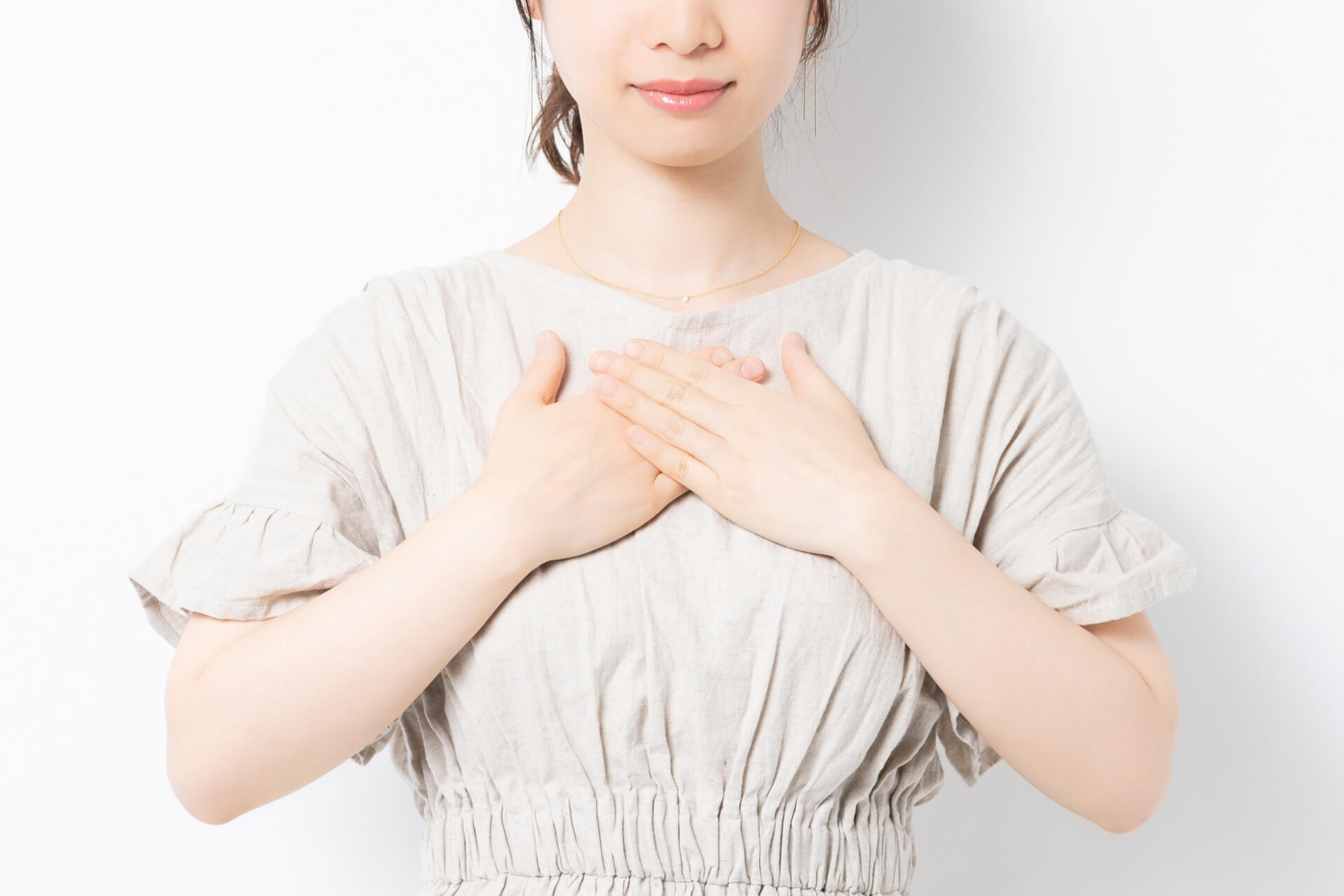 小さい胸に手を当てる女性